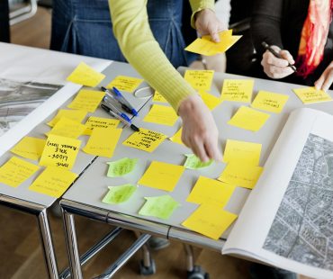 Cropped image of business people strategizing with sticky notes in office